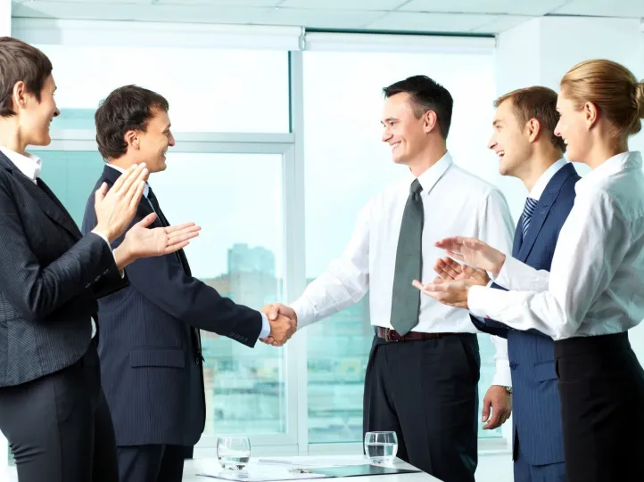 A group of people in suits shaking hands.