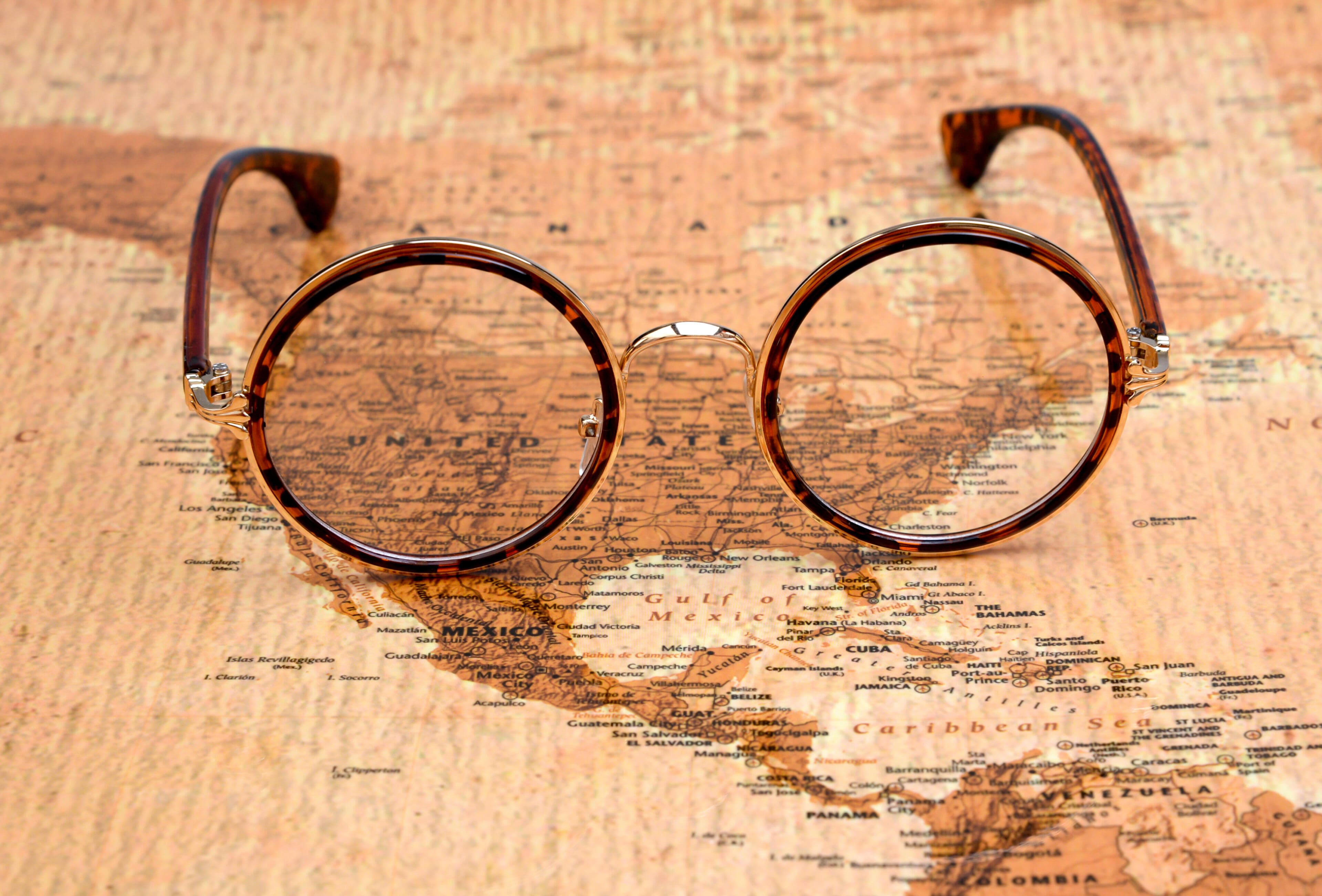 A pair of glasses sitting on top of a map.